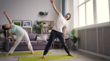 Evde Kafkas eşi ile yoga yapan karışık ırk genç adam eğitim odaklı