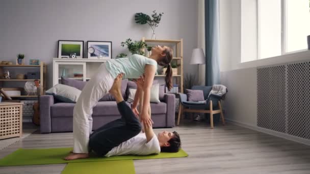 Leuke paar studenten beoefenen van yoga positie thuis oefenen samen — Stockvideo