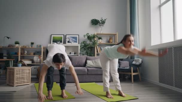 Vackra par gör yoga hemma öva på yogamattor fokuserade på övningar — Stockvideo