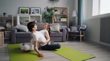 Çekici adam ve kız katta oturan düz çift yoga egzersizleri yapıyor