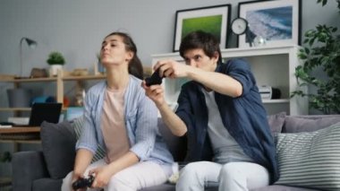 Neşeli çift boş zamanlarında rahatlatıcı eğlenmek evde video oyunu oynarken