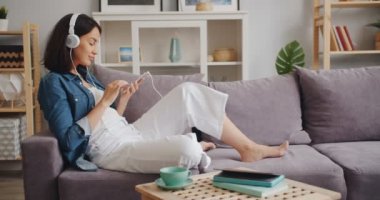 Evde akıllı telefon ekranına dokunmadan kulaklıkta müzik zevk neşeli bayan