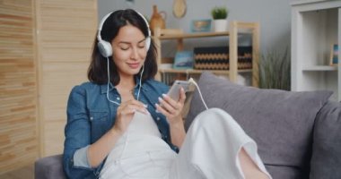 Kulaklık dokunmadan akıllı telefon ekranına müzik zevk kadın öğrenci