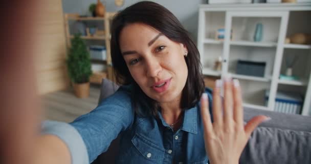 Άποψη της γοητευτική κυρία μιλάει κοιτάζοντας την κάμερα κάνοντας κλήση βίντεο — Αρχείο Βίντεο