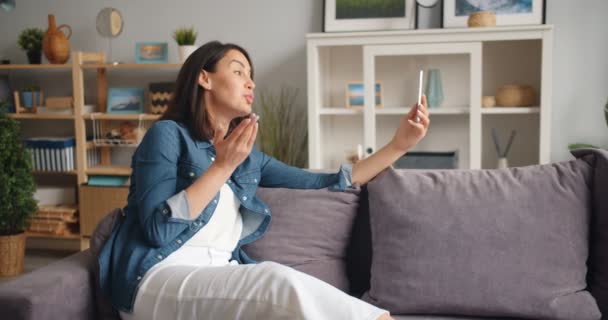 Pomalý pohyb hezké dívky při online video volání se smartphone doma — Stock video