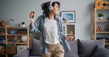 Kulaklık çekici kadın müzik tutan Smartphone dinleme dans