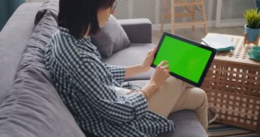 Yeşil mock-up ekran dokunarak ekran ile tablet kullanarak kız yavaş hareket