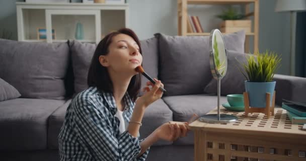 Belle femme se maquillant avec une brosse regardant le miroir à la maison — Video