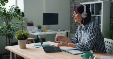 Kadın laptop kullanarak dans kulaklıklar müzik dinleme iş rahatlatıcı