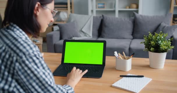 Lambat gerak orang menggunakan komputer laptop dengan hijau mock-up layar di rumah — Stok Video