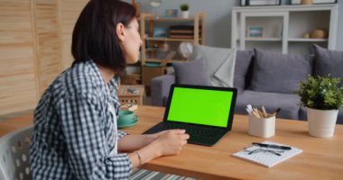 Öğrenci genç bayan izliyor laptop ile yeşil ekran gülümseyen içinde daire