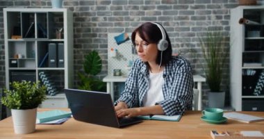 Ofis müzik dinleme laptop ile çalışan kulaklıklar genç bayan