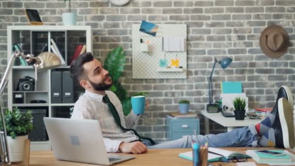 Trabajador de oficina sonriente tomando café y relajándose durante el descanso en el trabajo — Vídeo de stock