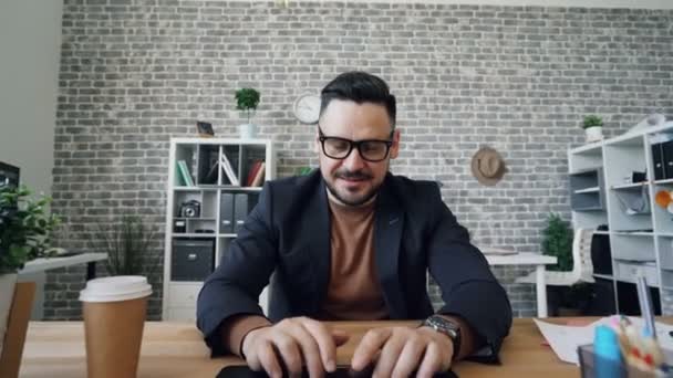 Масштабний портрет красивого чоловіка, який працює з ноутбуком в офісі — стокове відео