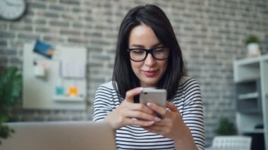 Akıllı telefon ile mutlu kız ekran dokunmadan iş yerinde sosyal medya zevk