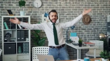 Neşeli işadamı ofiste eğlenmek şarkı müzik dans dinlerken
