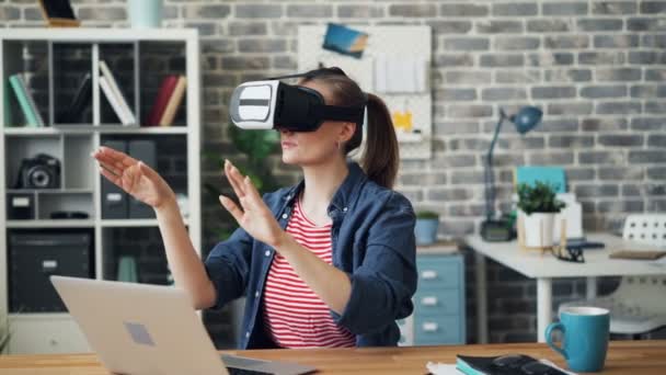 Trabajador de oficina en gafas de realidad aumentada moviendo las manos sentado en el escritorio — Vídeos de Stock