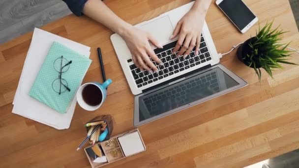 Las manos femeninas que escriben usando el ordenador portátil en la oficina que comunica en el trabajo — Vídeo de stock