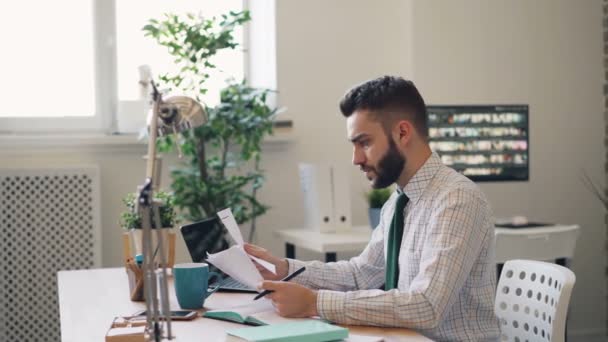 Стресс парень читает бизнес-контракт качает головой бросая ручку в офис — стоковое видео