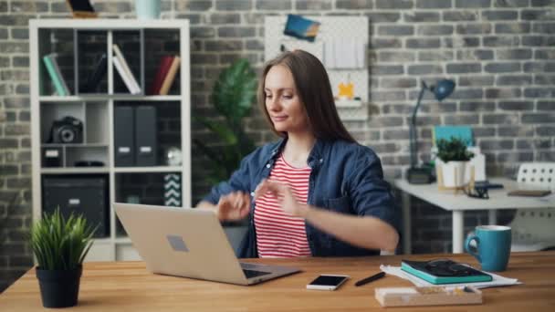 Fröhliches Mädchen lächelt entspannt bei der Arbeit nach der Verwendung von Laptop-Computer im Büro — Stockvideo