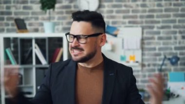 Ofiste bağıran ve kamerayı işaret eden kızgın sakallı adamın portresi