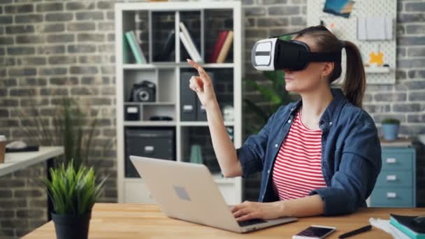 Mladá žena pomocí brýle virtuální reality v práci pohybující se ruce během přestávky — Stock video