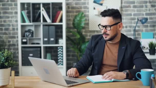 Man van middelbare leeftijd met behulp van laptop in kantoor dan slapen op Bureau rusten na het werk — Stockvideo