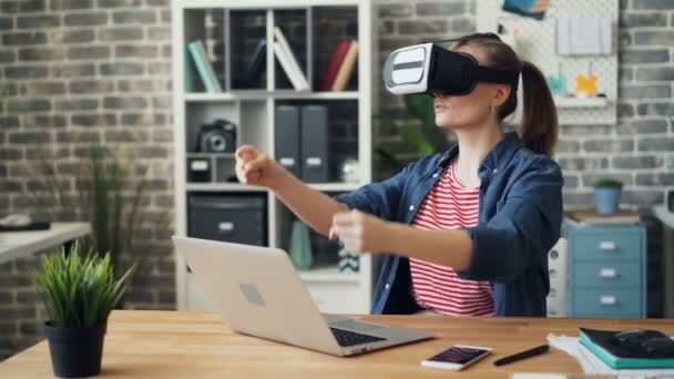 Flicka ha kul med Virtual Reality glasögon rörliga armar körning i Office — Stockvideo