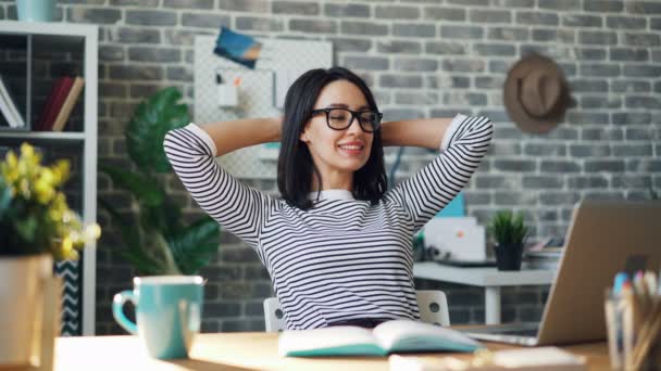 Boucle sans couture de jeune femme souriante regardant l'écran d'ordinateur portable dans le bureau — Video