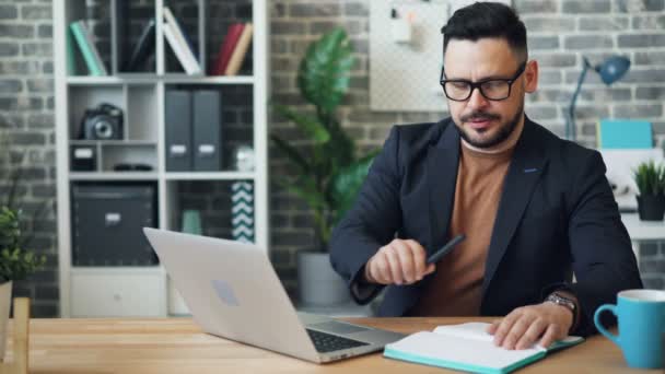 Stanco impiegato ragazzo sta usando il computer portatile poi togliersi gli occhiali toccare il viso — Video Stock