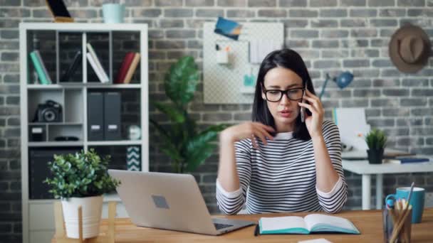 Arg ung dam talar på mobiltelefon i Office diskuterar problem på jobbet — Stockvideo
