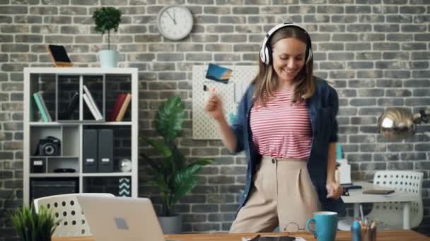 疯狂的企业家在办公室跳舞，通过耳机听音乐 — 图库视频影像