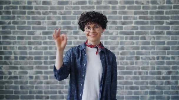 Retrato de hipster alegre mostrando gesto de la mano OK sonriendo mirando a la cámara — Vídeos de Stock