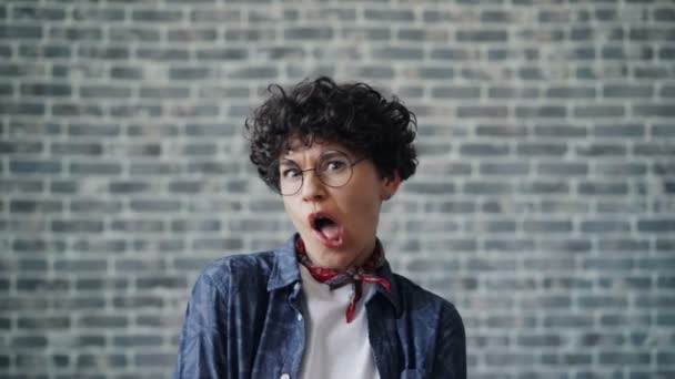 Portrait of joyful young woman making funny faces on brick background — Stock Footage Portrait of joyful young woman making funny faces on brick background Video Clip