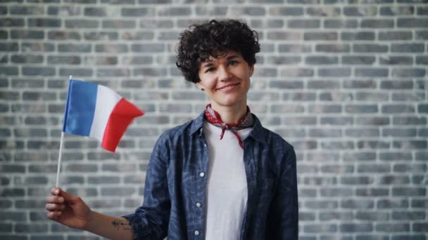 Retrato en cámara lenta de la dama francesa sosteniendo la bandera oficial de Francia y sonriendo — Vídeos de Stock