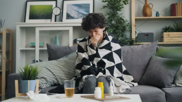 Jovem senhora sofrendo de tosse e dor de garganta embrulhando o corpo em cobertor em casa — Vídeo de Stock