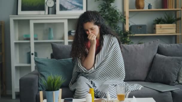 Zoom-in de niña enferma tosiendo y limpiando la nariz corriendo en el apartamento — Vídeo de stock