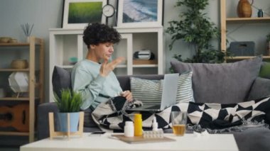 Öksürük öğrenci hapları termometre gösteren dizüstü bilgisayar kullanarak online doktor konuşuyor