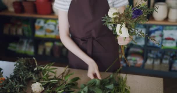 Fiatal nő virágüzlet rendez szép virágok összetétele az üzletben — Stock videók