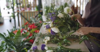 Kompozisyon oluşturma çiçek dükkanında çiçek düzenleyen satış kadın yavaş hareket