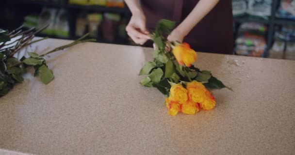 Blommor försäljare göra vackra sammansättningen av rosor som arbetar i butik — Stockvideo