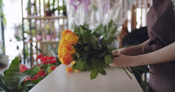 Creatieve meisje bloemist arrangeren bos van rozen in mooie compositie op het werk — Stockvideo