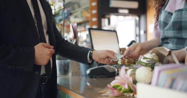 Guy kund ger pengar pengar till kassan sedan ta blommor från florist — Stockvideo
