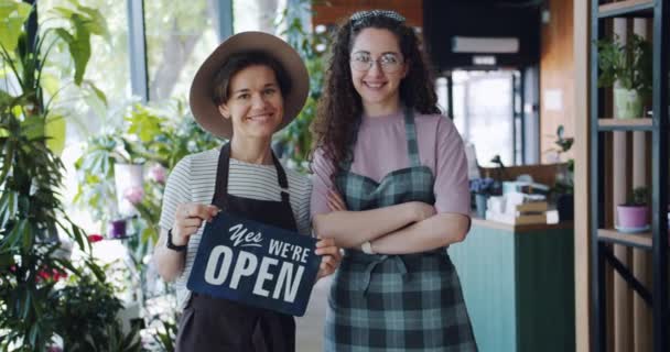 Porträtt av Pretty Florister i blomsteraffär med öppen skylt Start Business — Stockvideo