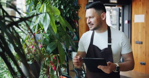 꽃가게 매니저, 꽃다발 만져식물 미소와 태블릿 사용 에 매장 작업 — 비디오