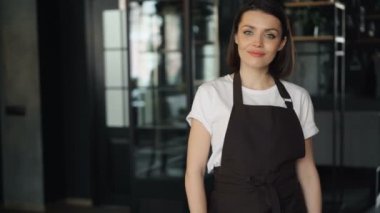 Yeni kafede duran açık tabela tutan apron mutlu iş kadını portresi