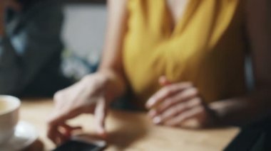 Modern cihaz kullanarak kafede akıllı telefon ile online ödeme yapan genç bayan
