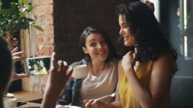 Pretty bayanlar kafede kahve içme ve akıllı telefon gülerek fotoğraf çekmek