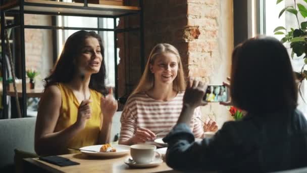 楽しい女性は、カフェで食べ物と一緒に写真を撮ってスマートフォンの画面に触れる — ストック動画