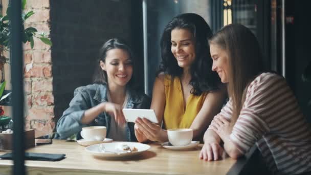 Група молодих жінок дивиться екран смартфона сміється пити каву в кафе — стокове відео
